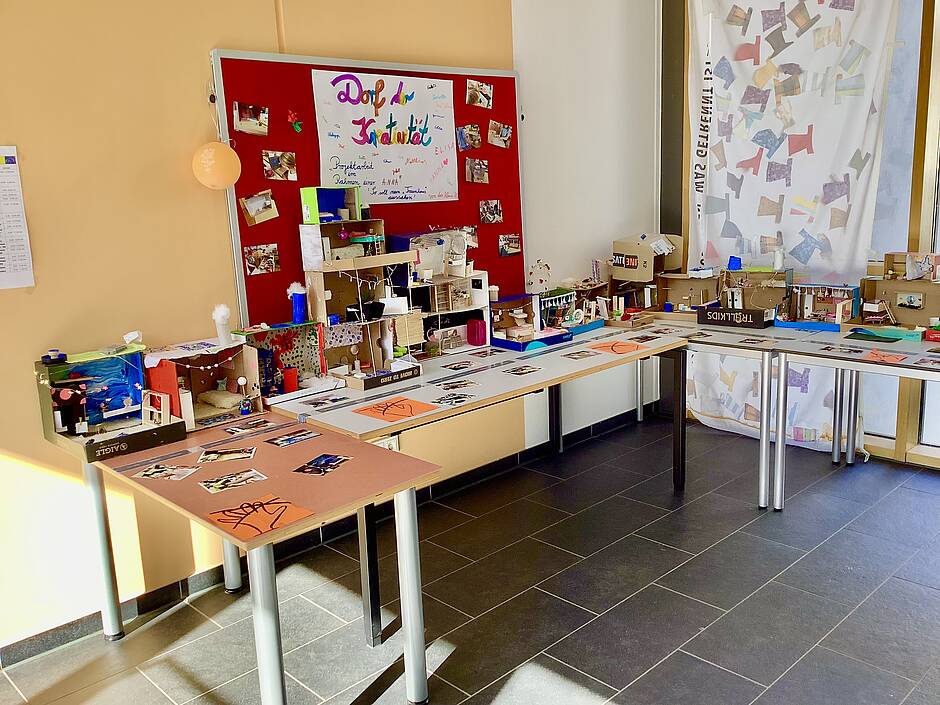 Man sieht eine Ausstellung von offenen Schuhkartons. Das Innenleben der Kartons wurde von den Kindern jeweils so gestaltet und eingerichtet, wie sie sich ihren Lieblings-Rückzugsort vorstellen.